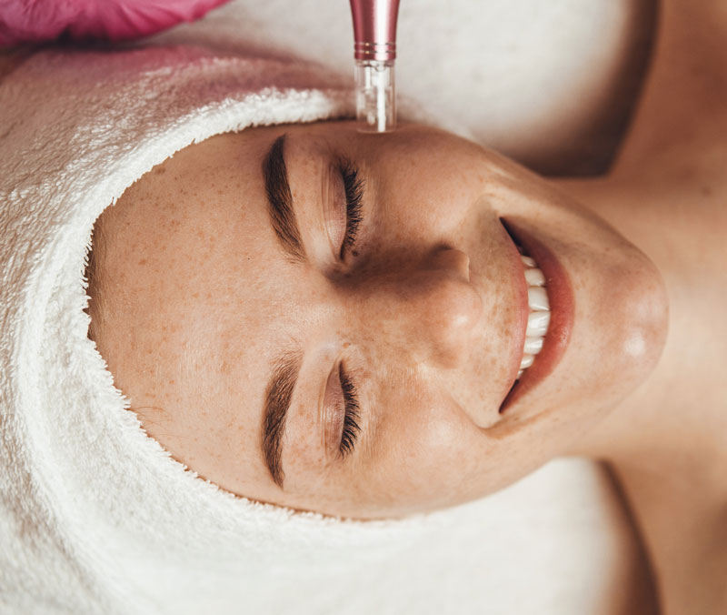 Woman smiling while receiving a treatment at Ellefson Lakeside Medical Asthetics.